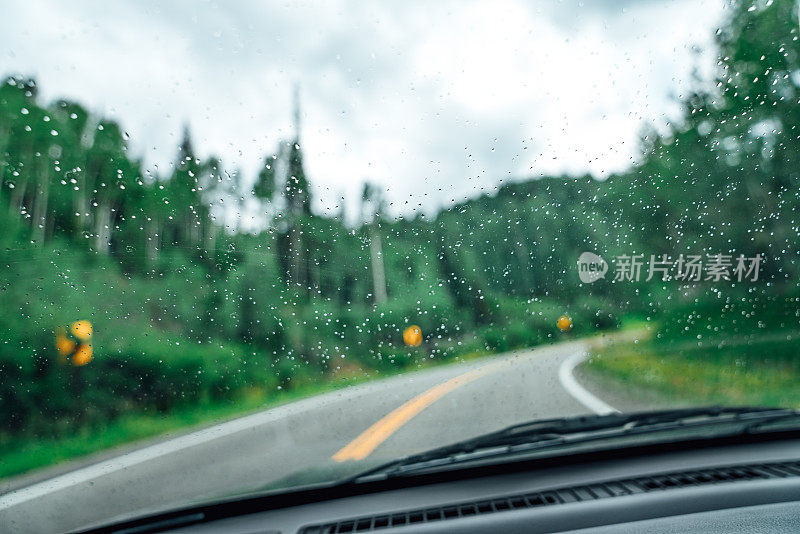 雨点聚集在65号高速公路上的司机的挡风玻璃在科罗拉多西部靠近大汇合点的国家森林风景小路上