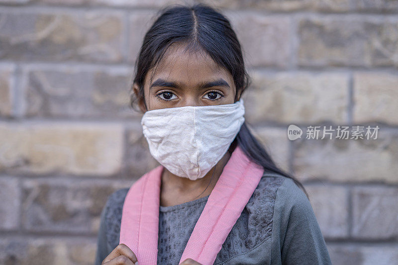 美丽的印度女孩戴着面具回到学校