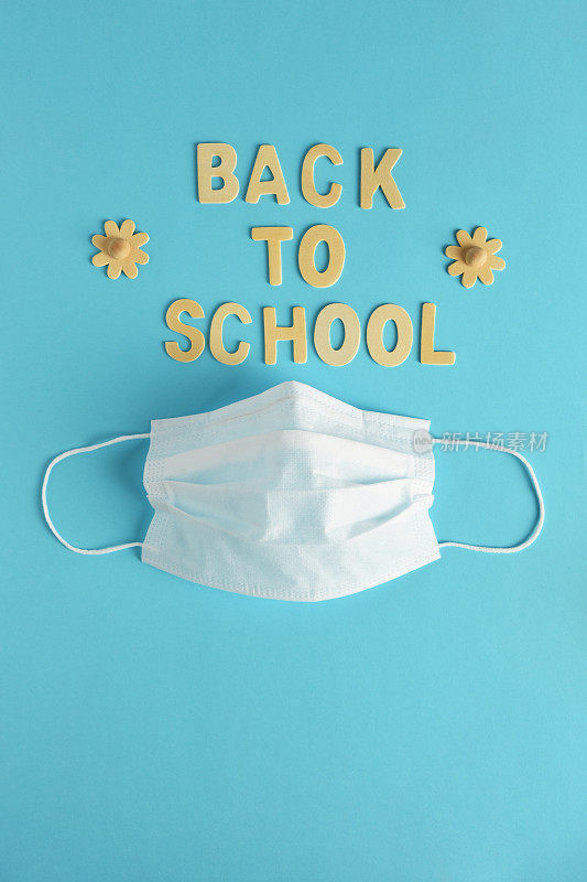 回到学校的概念，“回到学校”木质的字母和防护口罩