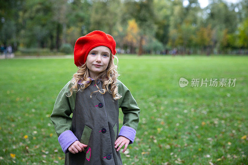 一个戴着红色贝雷帽的小女孩的肖像。