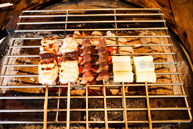 日式炒菜——鸡肉和蔬菜放在铁架上，用炭火烤。