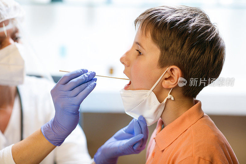 在聚合酶链反应测试中，男孩戴低防护口罩，张大嘴巴