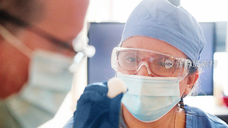 女性卫生工作者在出诊期间使用纱布球与病人的特写