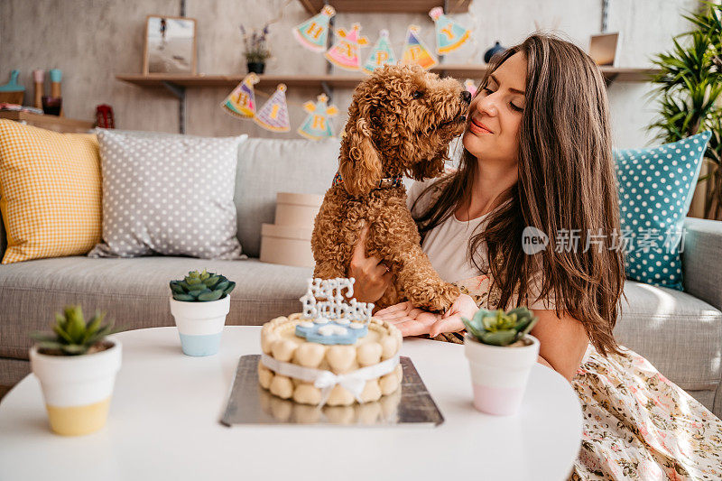 年轻女子和她的狗庆祝宠物的生日