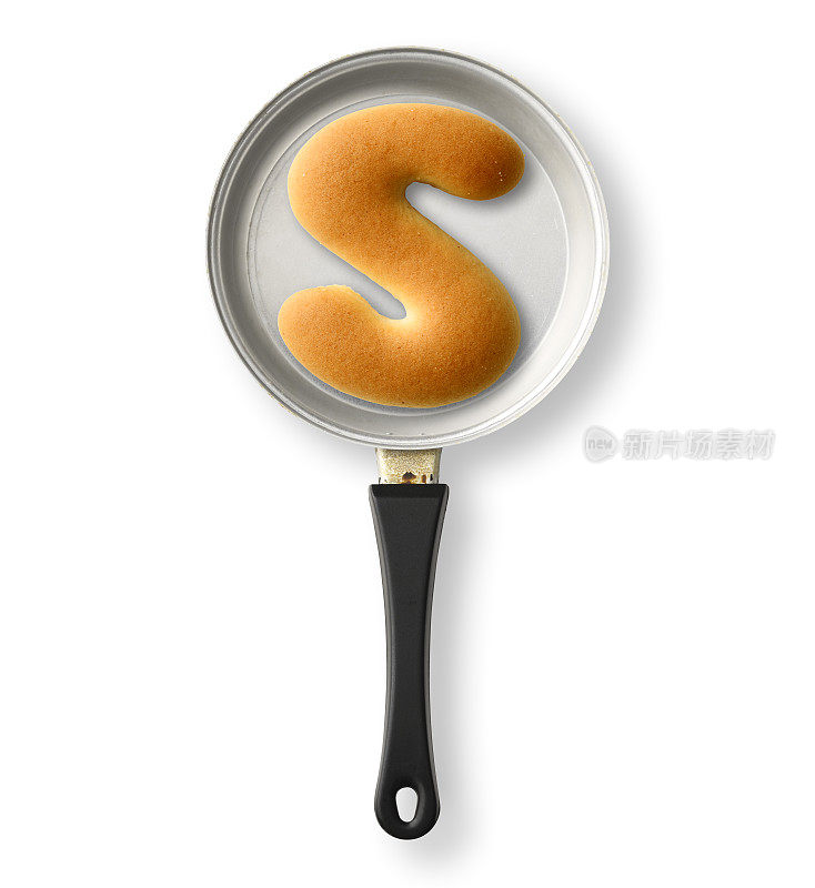 孤立的镜头的大写字母饼干S在一个旧的玩具煎锅，在白色的背景