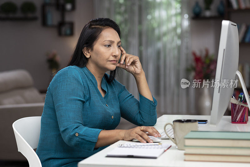 一个商业女性和教师在家里工作的照片:库存照片