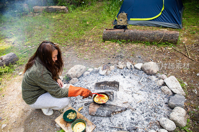 一个女人在野外生火做饭