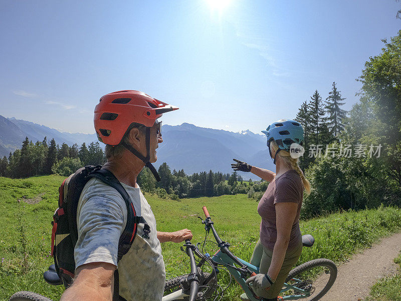 山地自行车夫妇在阳光明媚的自行车道上放松