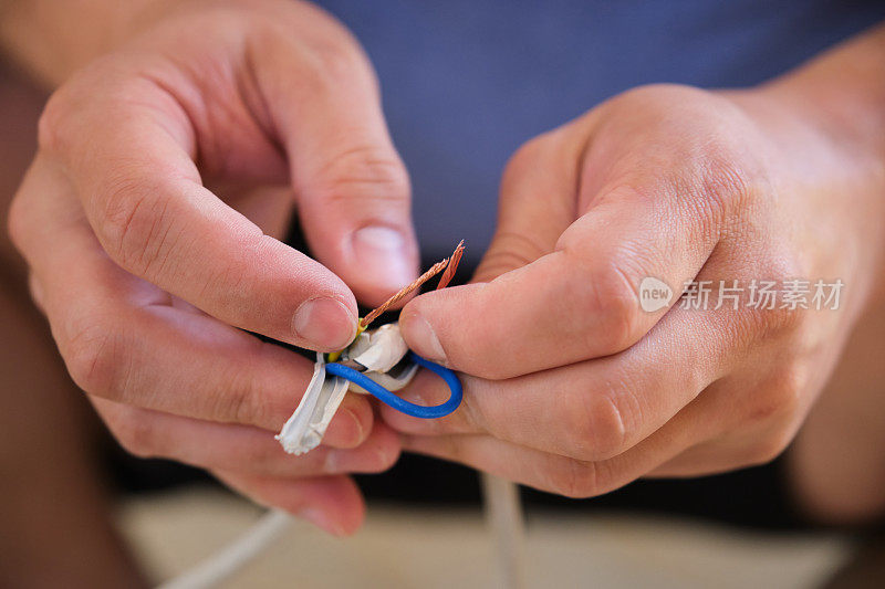 年轻人动手修理或接电线。