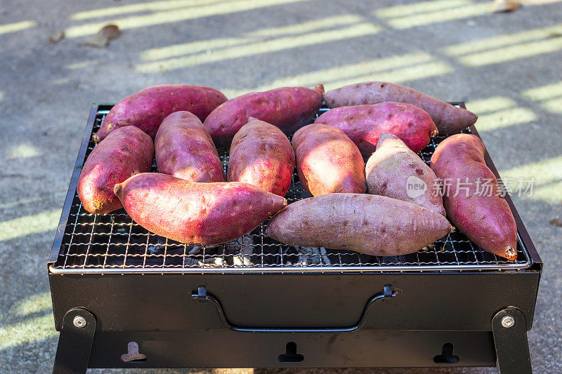 日本红薯在炭炉上烤。土豆含有纤维、硫胺素、钙、钾以及维生素a和C。