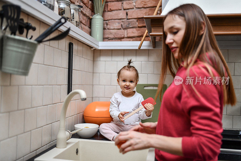 可爱的宝宝和妈妈一起学习洗水果