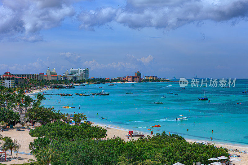 南加勒比海阿鲁巴棕榈海滩旅游胜地阳光明媚的早晨。几家海滩酒店和船停泊在近海。