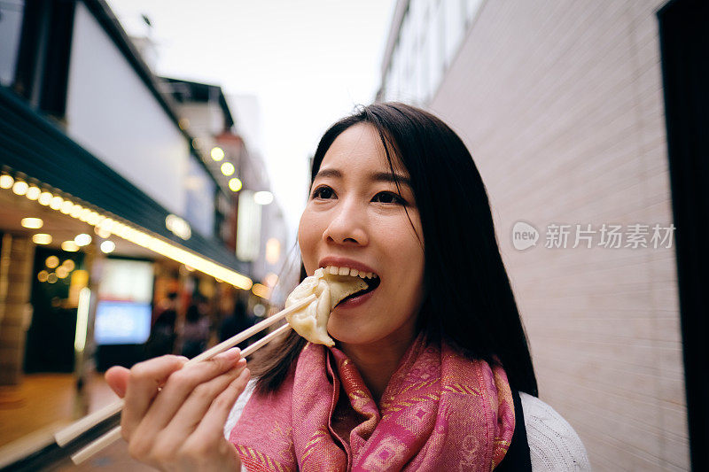 街上吃饺子的女人