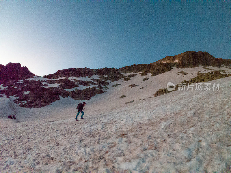 女登山者在雪道上攀登山峰