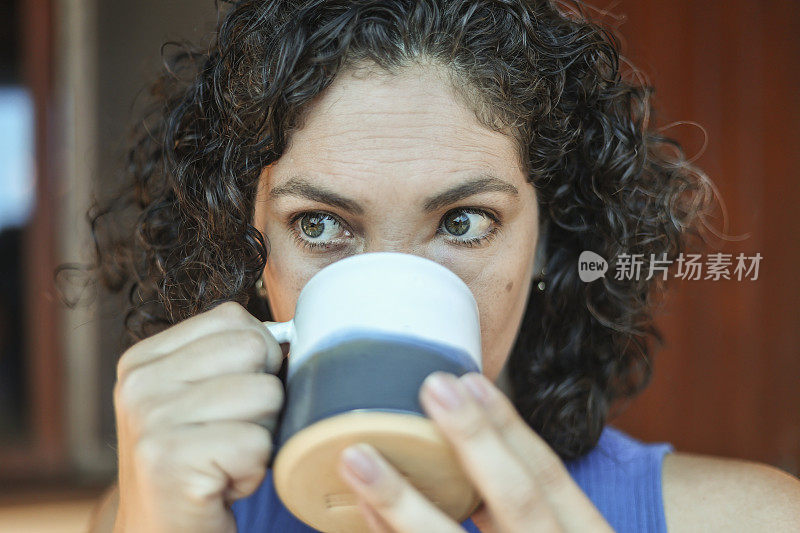 绿眼睛的女人用杯子喝茶