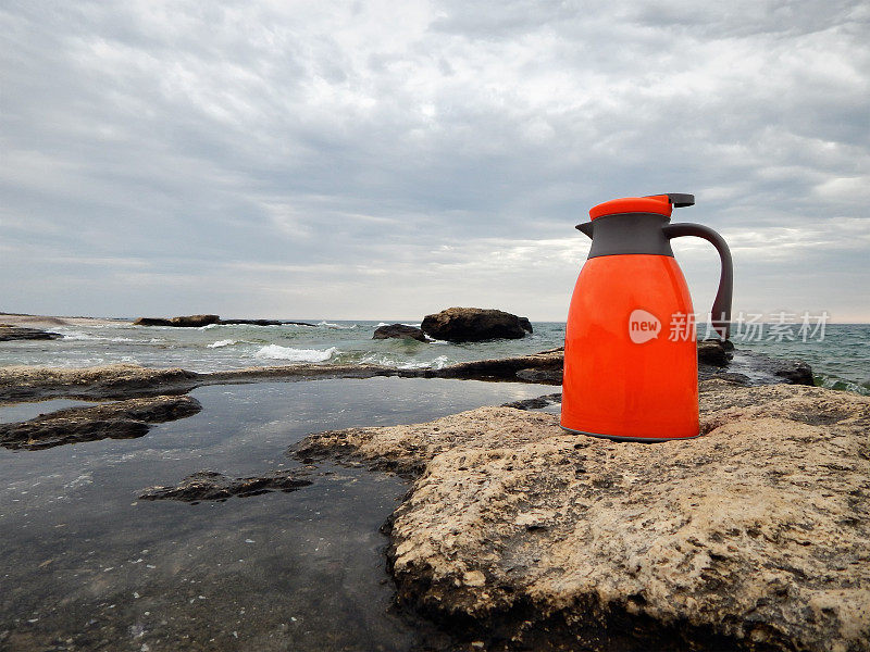岸边的橙色热水瓶。