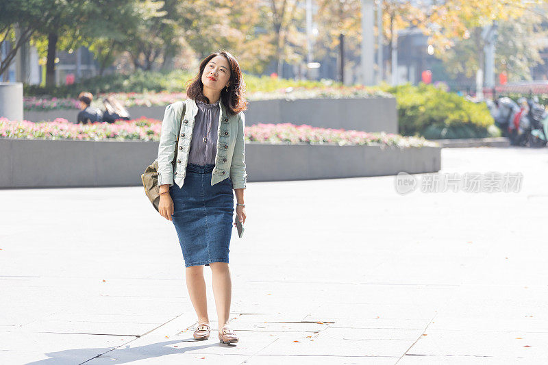 美丽的年轻女子通勤上班在市区的城市街道在早上