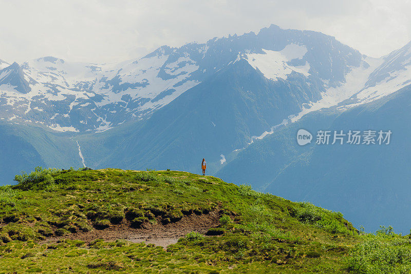 女子在远距离徒步旅行与背景风景秀丽的森莫尔阿尔卑斯山在挪威