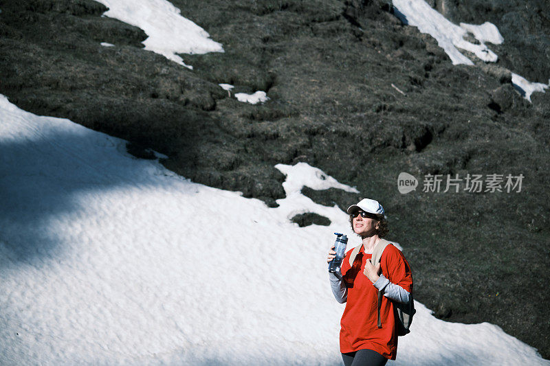 女徒步旅行者正在山里喝水