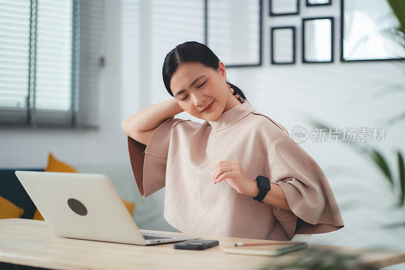 患有办公室综合症的亚洲女性坐在家里办公。