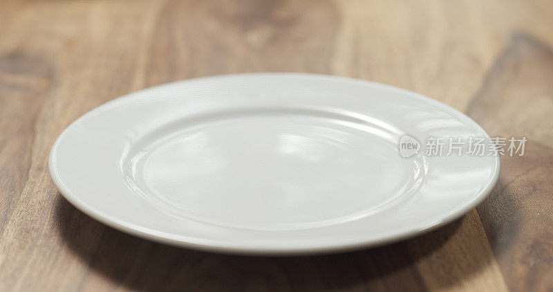 木桌上的白色空盘子