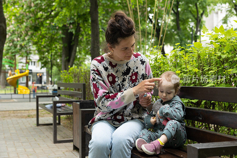 妈妈在公园里照顾她的孩子。