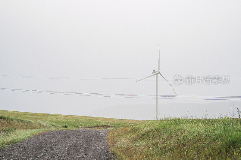 极简主义景观:风力发电机在绿色领域附近的道路，与山的背景，在雾中，戈里附近，格鲁吉亚