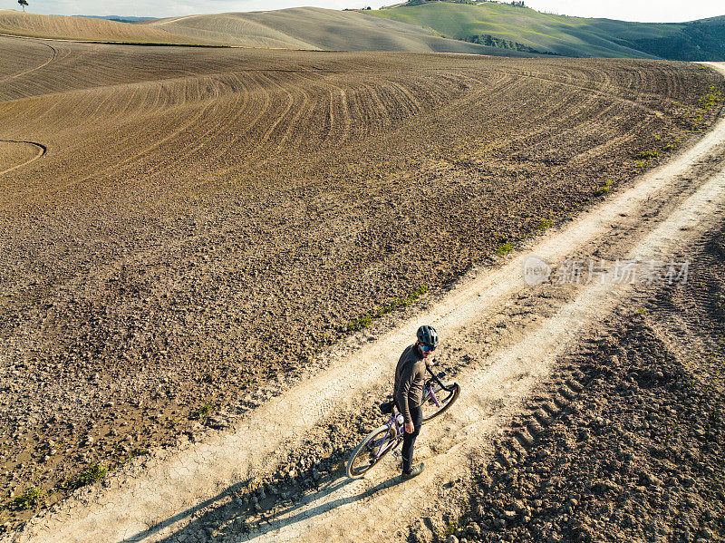 秋天，一名男子骑着沙砾自行车在山上骑行