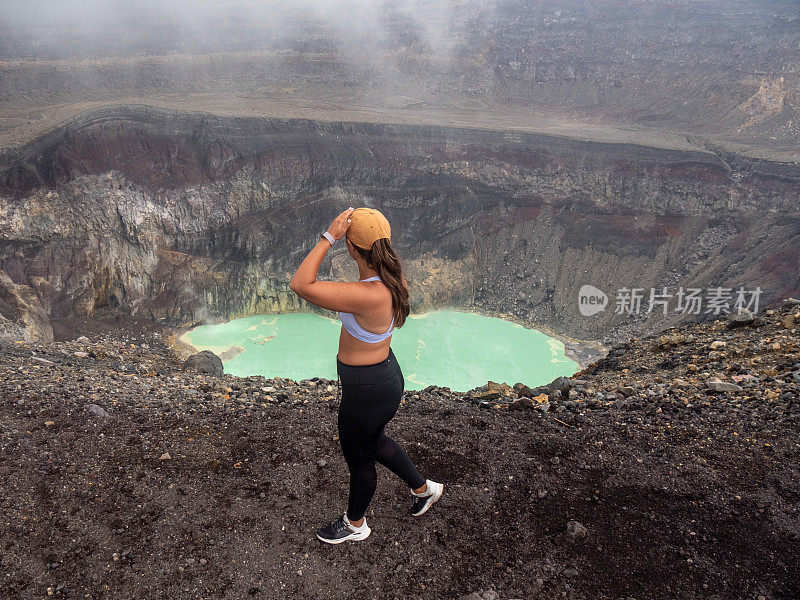 一位妇女走在火山口的山脊上
