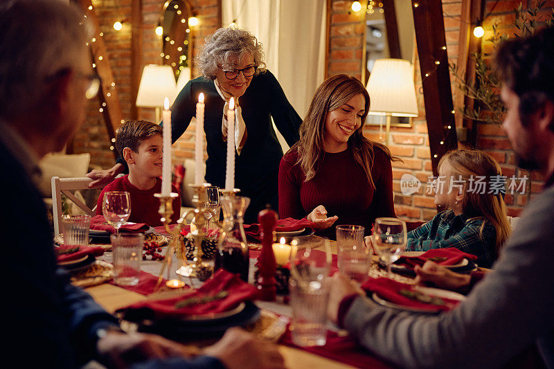 快乐的大家庭在餐桌上谈论圣诞晚餐。