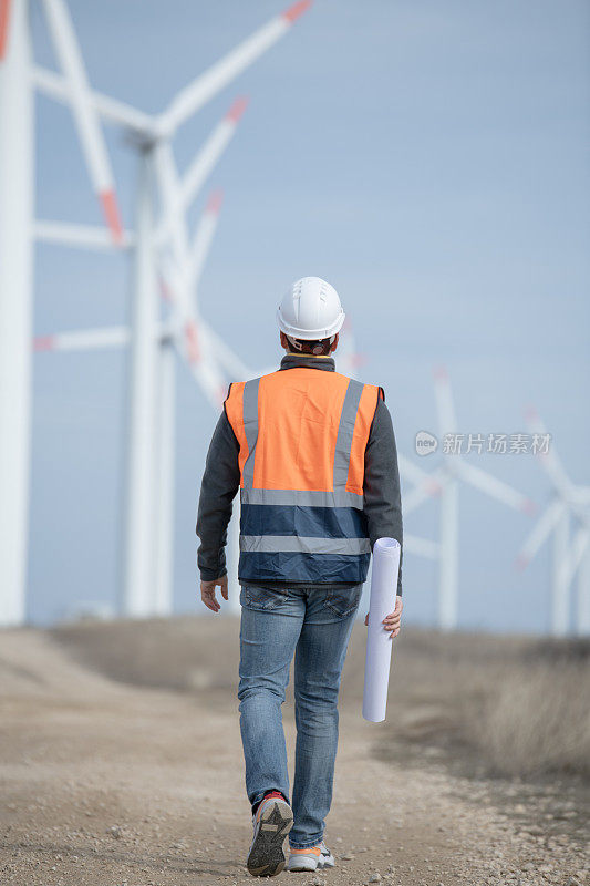 工程师在他设计和建造的风电场中行走。