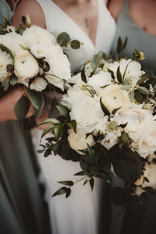 新娘和伴娘手持婚礼花束的特写