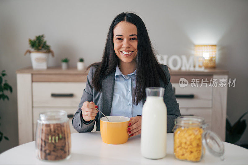 可爱的微笑女人在清晨吃早餐