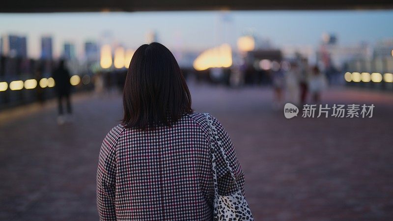 晚上走在东京台场市的女子