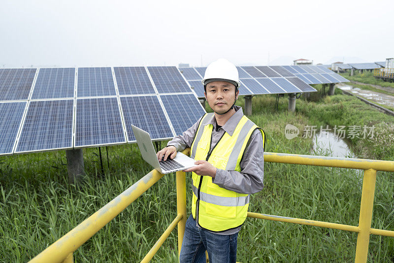 亚洲男工程师在检查太阳能发电板，自信地面对镜头