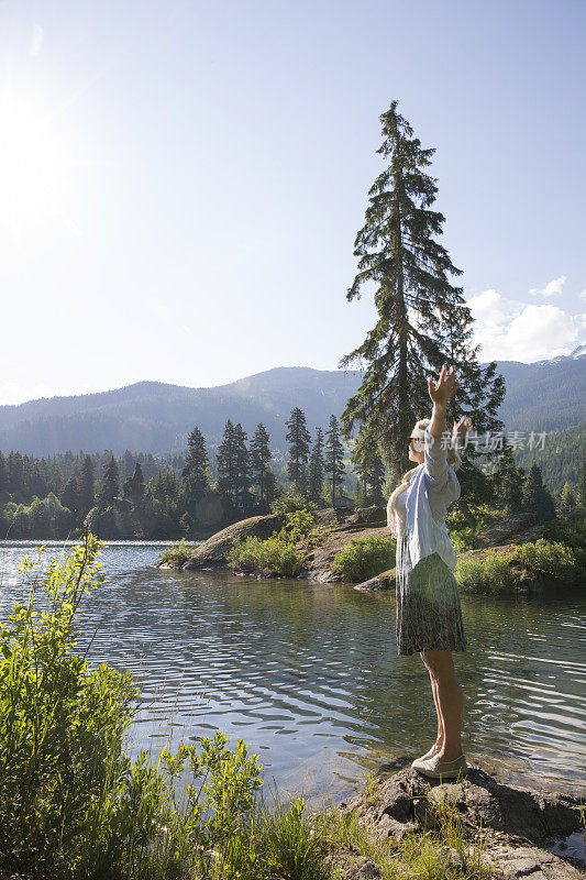 在惠斯勒，BC，加拿大的湖延伸的女人的观点。