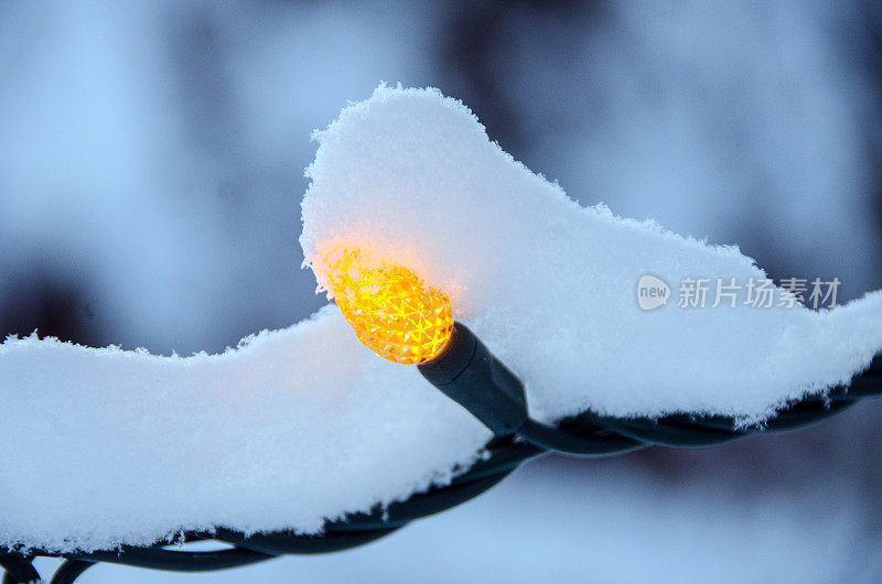 雪花覆盖的圣诞LED黄灯