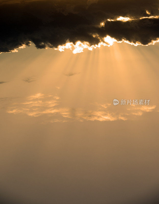 太阳从暗橙色的天空中穿过云层