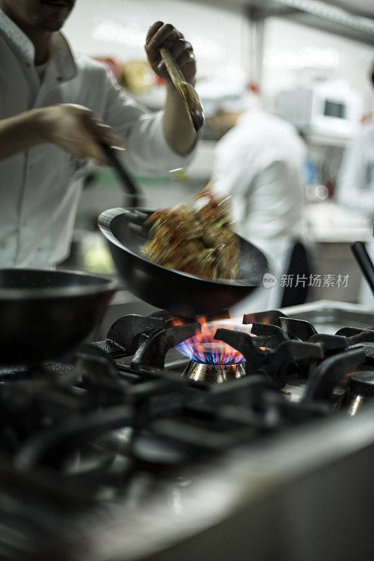 厨师在锅里翻炒食物