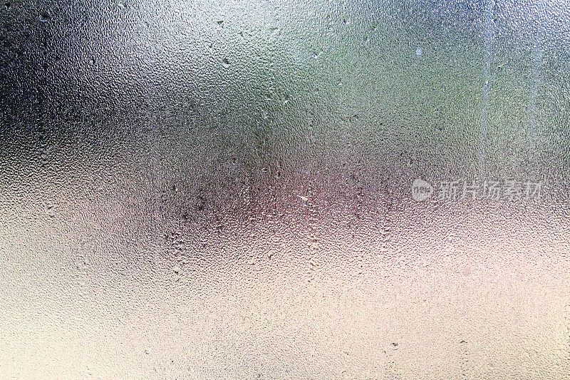 雨点和凝结在磨砂玻璃窗上
