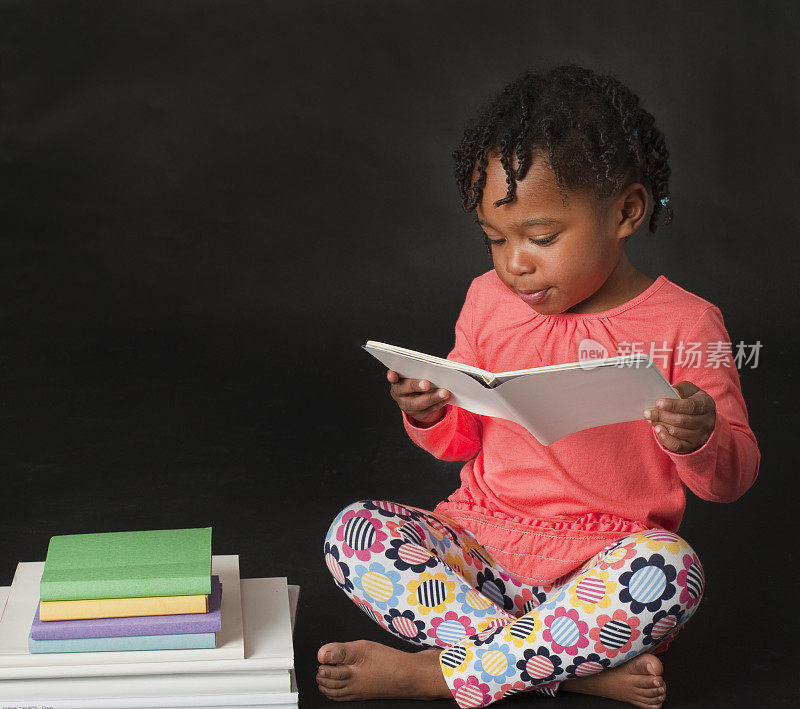 可爱的小女孩在看书。