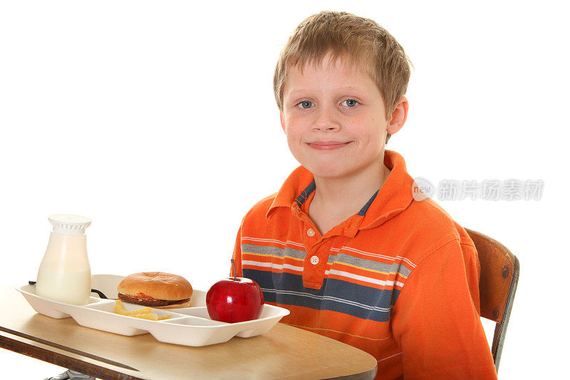 男孩在课桌上吃午饭