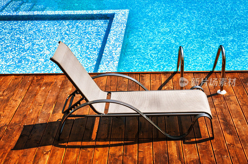 室外游泳池旁的空太阳躺椅