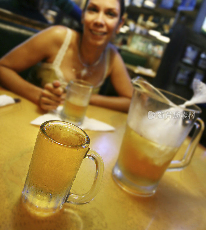 一个在生酒吧喝啤酒的女人