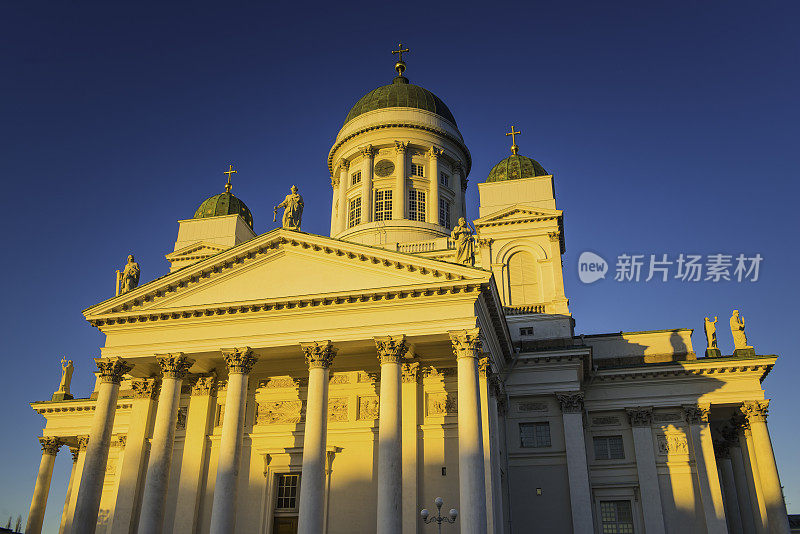 芬兰参议院广场上的赫尔辛基大教堂被金色的夕阳照亮