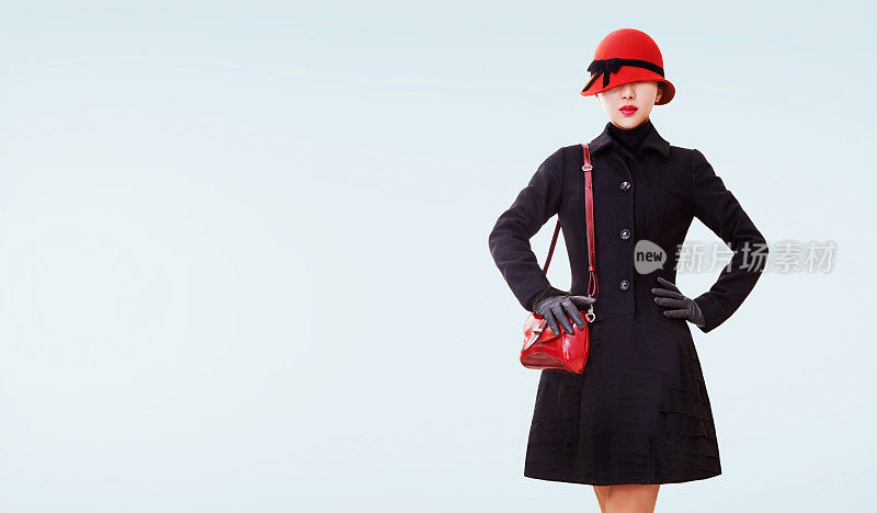 冬天的时尚外观。红色帽子，钱包和黑色外套分开。