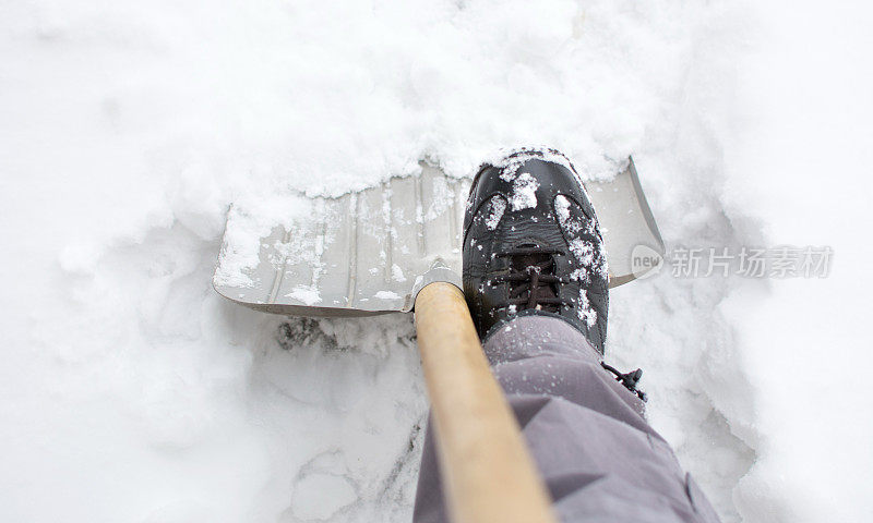 在积雪的院子里用雪铲铲雪