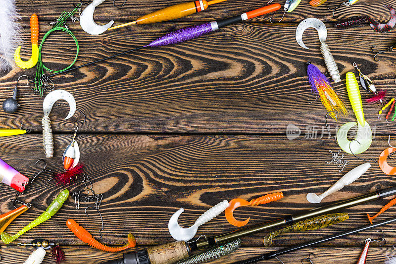 钓竿、钓具、鱼饵、卷轴，以木板为背景