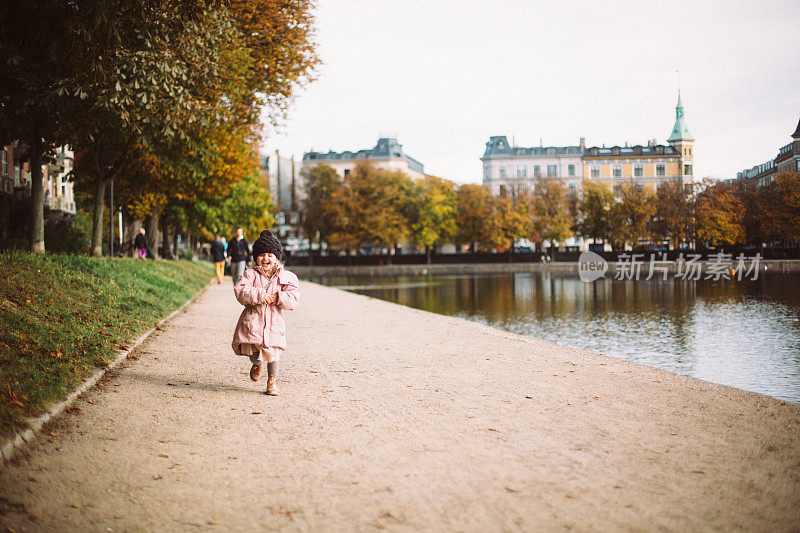 小女孩在哥本哈根的湖边跑步