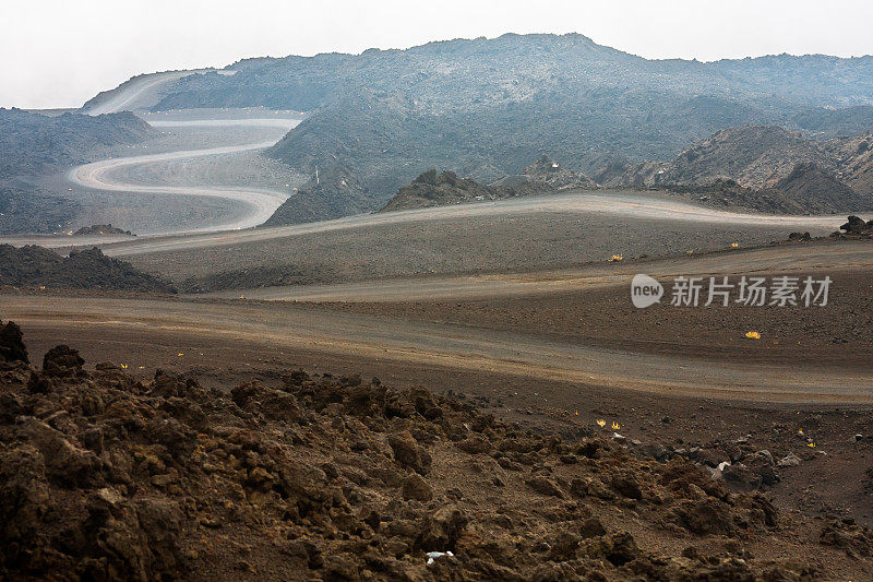 蜿蜒的道路穿过成堆的火山石头